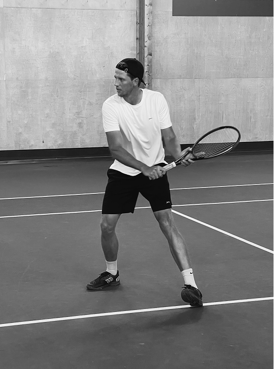 Tennistränare Fabian slår en backhand i Stockholms Tennishall