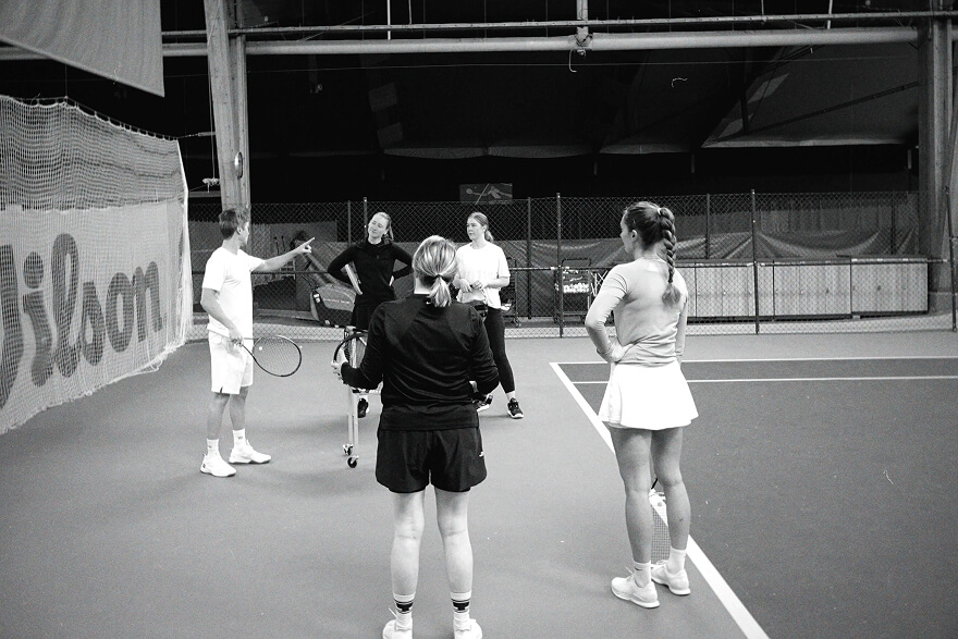 Vuxna tennisspelare under gruppträning på tennisbana i Stockholm