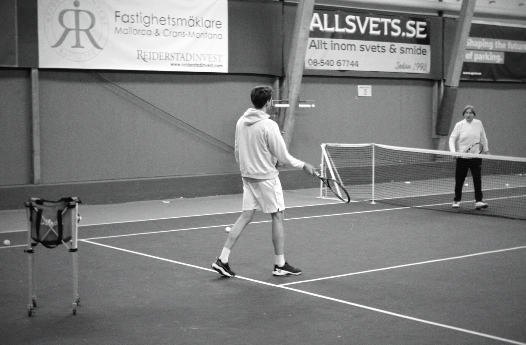 Tränare Fabian håller privatlektion i tennis på bana i Stockholm